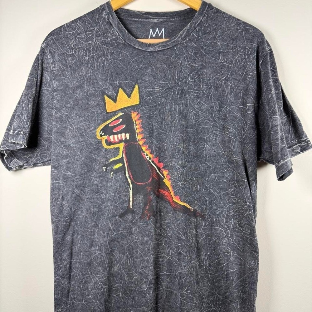Official BASQUIAT™ licensed graphic tee featuring a crowned dinosaur design